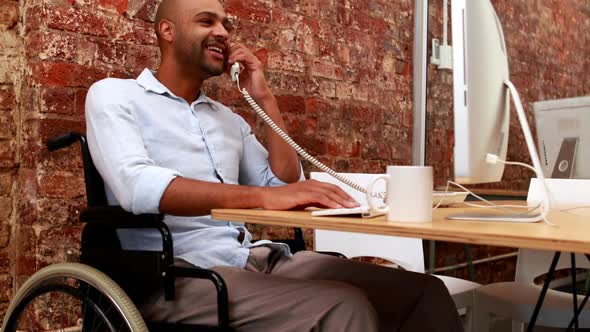 Casual Business Man in Wheelchair Working at his Desk