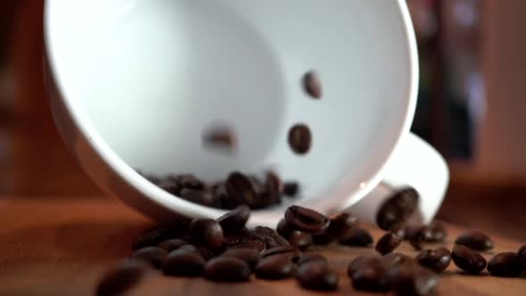 Empty Coffee Cup with Falling Coffee Beans in Slow Motion