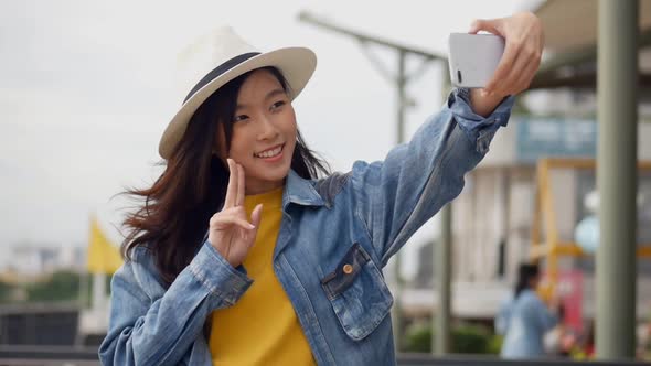 Beautiful Asian woman taking selfies on a smartphone.