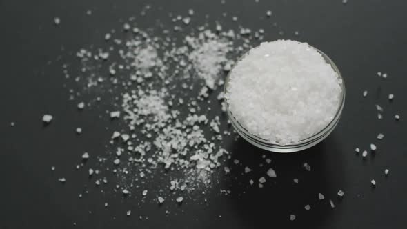 Animation of salt in a bowl and pile of salt on black background