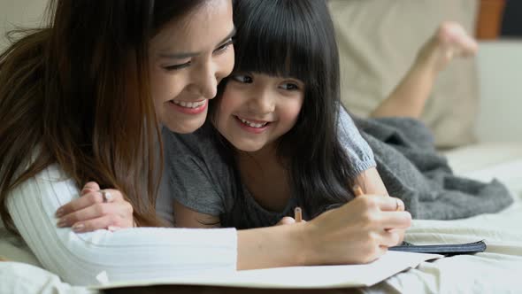 beautiful asian single mom with cute daughter happiness moment time teach homework
