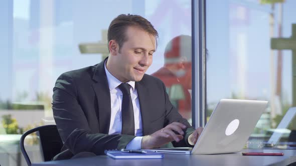 Businessman drinks water while working.