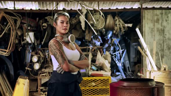 Attractive young woman mechanical worker repairing a vintage car in old garage.