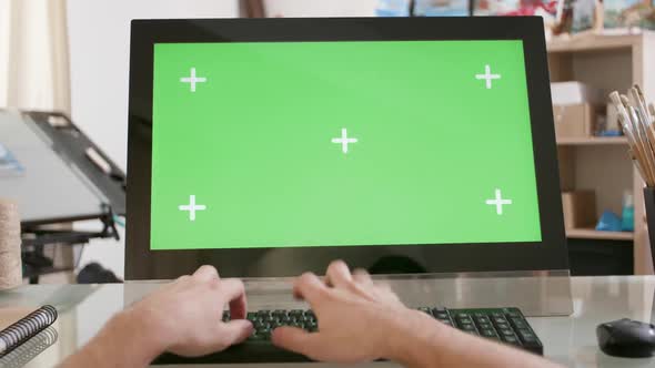 Young Artists Hands Typing a Text on the Keyboard in Front of a Green Screen