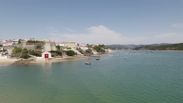 Drone flying above Small vessels moored on Mira River, Scenic coastline of Vila Nova de Milfontes