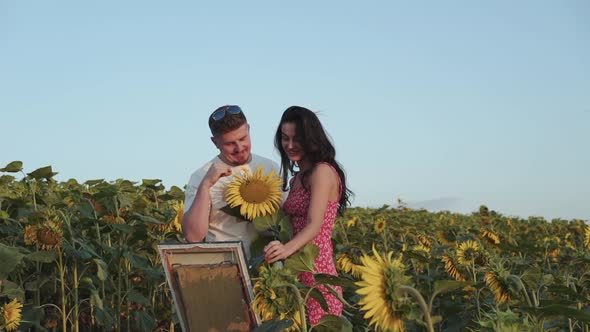 Pretty Female Artist Painting Her Man Presents a Sunflower and They Have a Fun