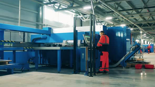 Male Worker Is Managing a Large Cutting Machine