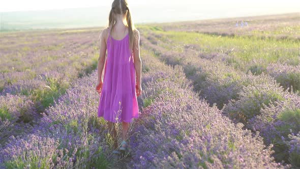 Woman in Lavender Flowers Field at Sunset in White Dress and Hat