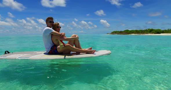 Young couple on honeymoon vacation enjoy life on beach on paradise white sand background 