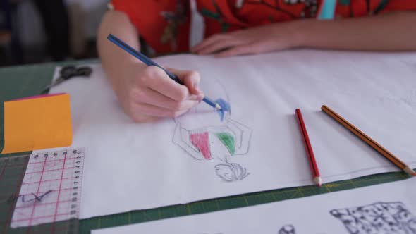 Caucasian woman drawing in fashion office