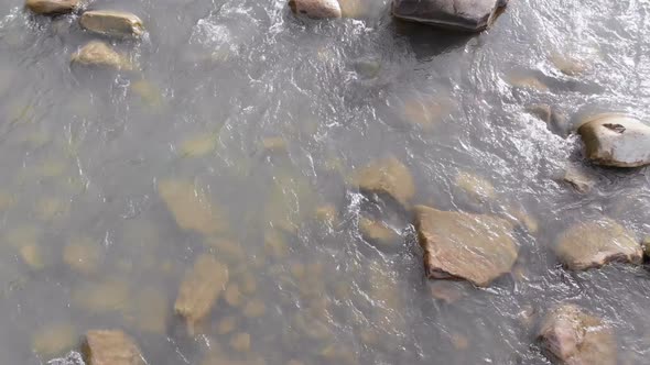 Flying Over Wild Mountain River Flowing with Stone Boulders and Rapids