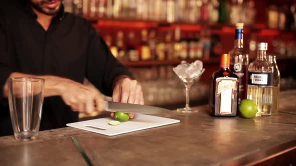 Bartender slicing lime for cocktail