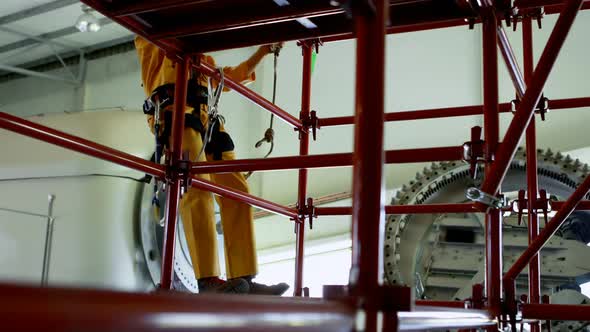 Male worker moving down from scaffolding at solar station 4k