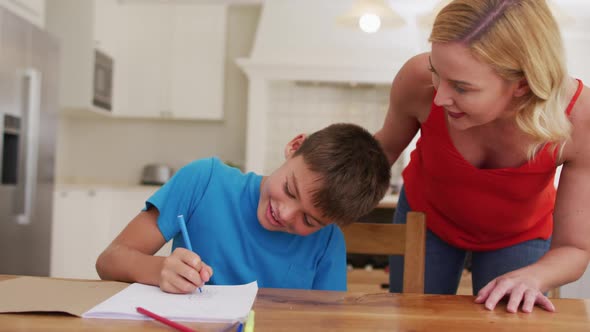 Caucasian mother helping her son with his homework at home