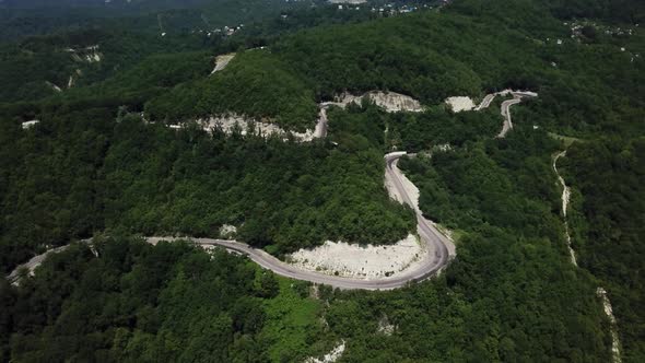 Aerial View From Above of Curve Road with a Car on the Mountain with Green Forest in Russia