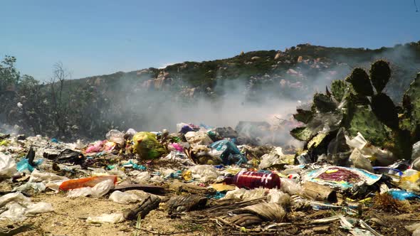 Pile of plastic waste in garbage dumb landfill, toxic smoke and fire burning open air disposal of wa