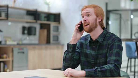 Cheerful Beard Redhead Man Talking on Smartphone in Cafe 