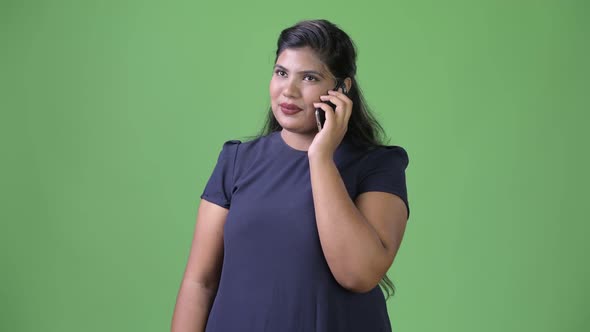 Young Overweight Beautiful Indian Businesswoman Against Green Background