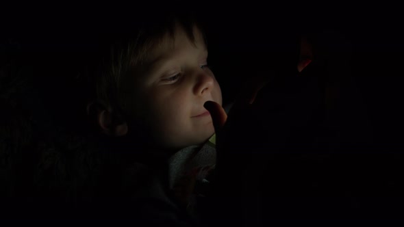 Little Boy Sitting in a Dark