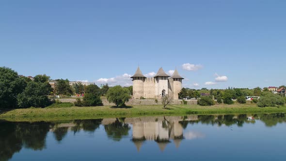 drone aerial shot of soroca fortress reflected in water with flying bird