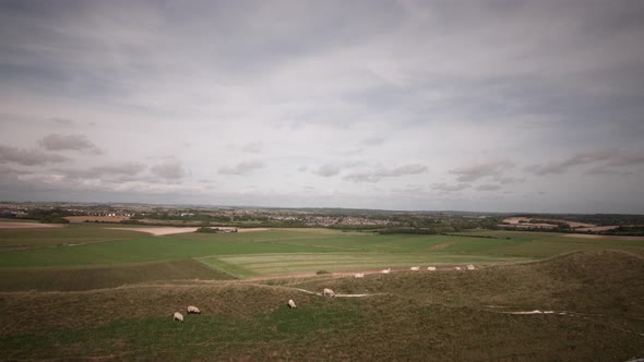 Timelapse of Dorchester and Poundbury in Dorset. From the top of Maiden Castle. People and sheep can