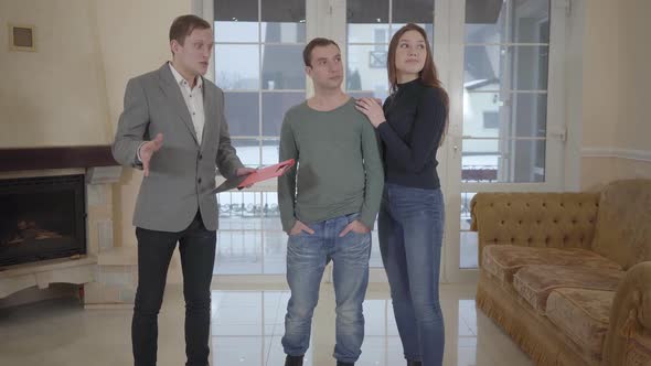 Successful Real Estate Agent Shows Young Confident Cute Married Couple a New Home