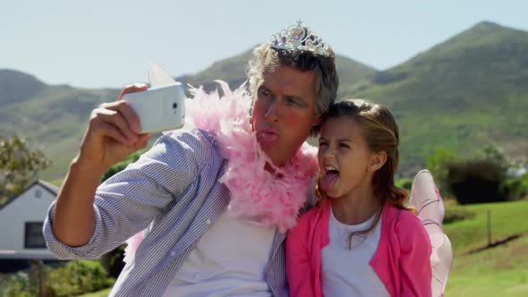 Smiling father and daughter in fairy costume taking selfie with mobile phone 4k