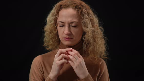 Portrait of Anxious Caucasian Woman Thinking Talking to Herself at Black Background