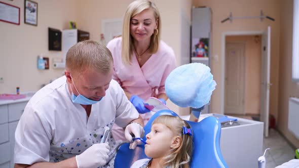 Smiling girl at dentist's visit. Little child is sitting in dentist chair.