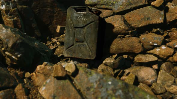 Old Rusty Metal Canister for Gasoline Fuel at Rocks