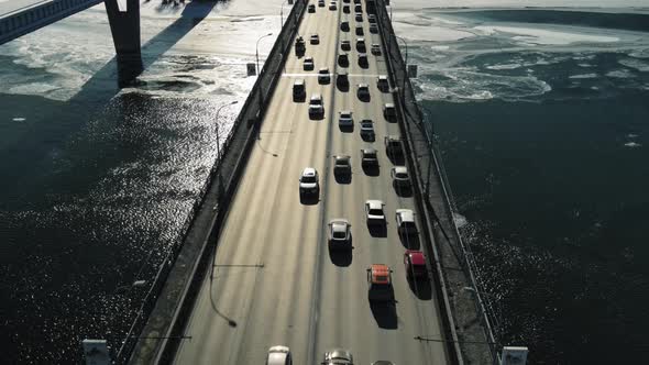 Cars Move Across the Bridge in the Background of Back Sunlight