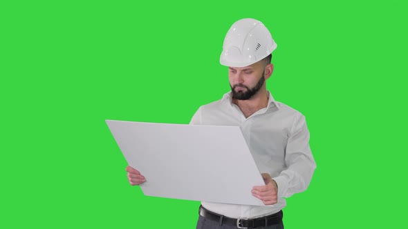 Man Engineer Walking in Helmet Looking at Project of Reconstruction on a Green Screen, Chroma Key