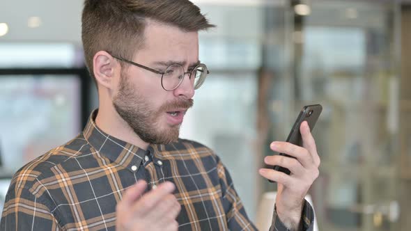 Portrait of Sad Young Designer Getting Loss on Smartphone