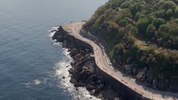 Beautiful coastal road on rocky cliffside, tropical coastline, aerial drone view