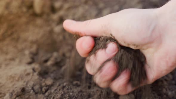 The Hand Rubs Soft Loose Soil Closeup