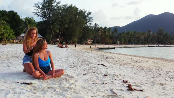 Beautiful ladies look beautiful on relaxing bay beach time by blue lagoon with white sand background