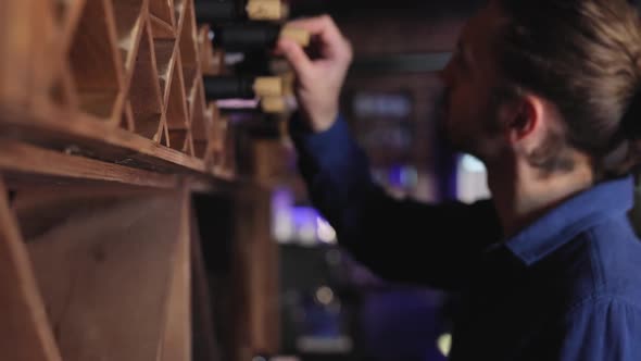 Wine Restaurant. Handsome Man Choosing Wine Bottle On Shelf