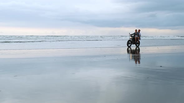 Young Couple Hipsters Riding Retro Motorcycle on the Beach Outdoor Portrait Riding Guy