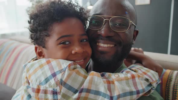 Portrait of Joyous Afro Father and Little Son Hugging Each Other at Home