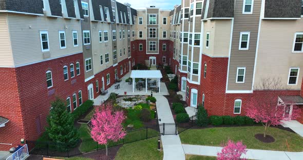 Large apartment building. Retirement home in USA. Rising aerial in pretty spring scene.  Outdoor cou