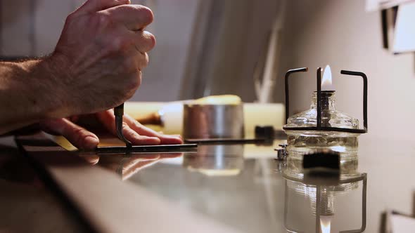 A Man Cuts the Piece of Pressed Leather with Hot Solder with a Heating Device on the Foreground