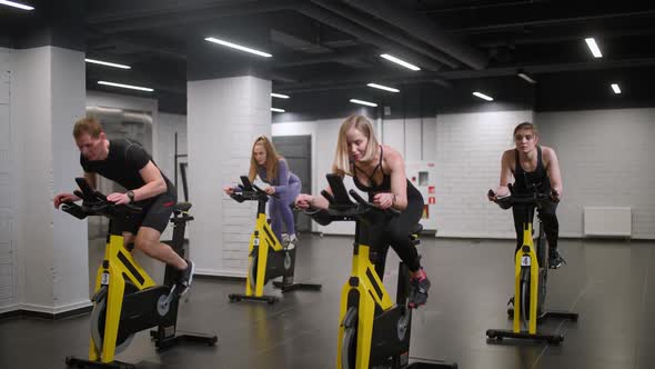 Wellness Group of People is Training on a Spin Bikes Performs Aerobic Endurance Training on the