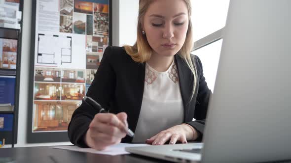 Woman Entrepreneur Writing with Pen Business Document on Table in Modern Office