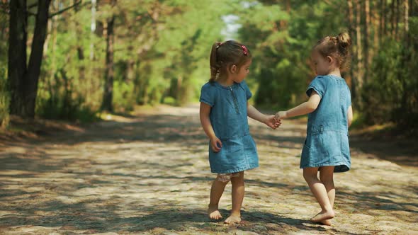 Girls are Walking on a Forest Road