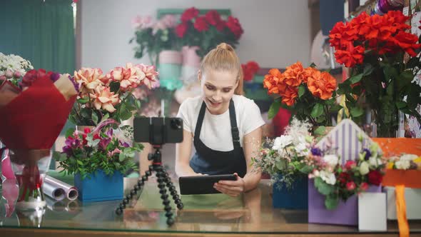 Female Florist Discusses the Order By Talking on Video Call Using a Smartphone and Screen Tablet in