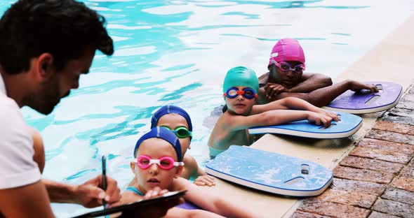 Coach giving swimming lesson to his students