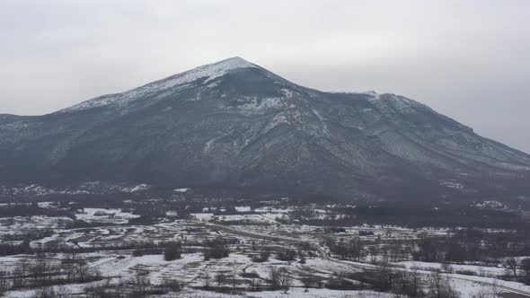 Ascending over the winter landscape with mountain Rtanj 4K drone video