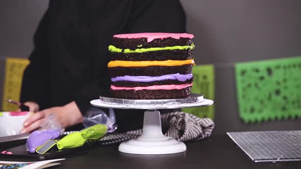 Time lapse. Step by step. Baker frosting multilayer chocolate cake with buttercream frosting.