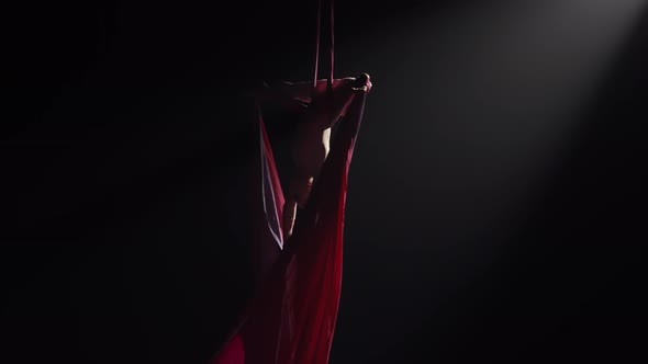 Young Female Circus Gymnast Spins Hanging Upside Down on Aerial Silk