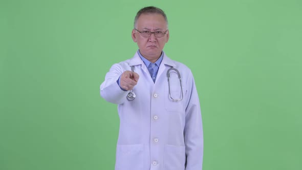 Angry Mature Japanese Man Doctor Pointing at Camera